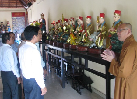 Trụ trì chùa đang giới
 thiệu bộ tượng La Hán với khách tham quan.